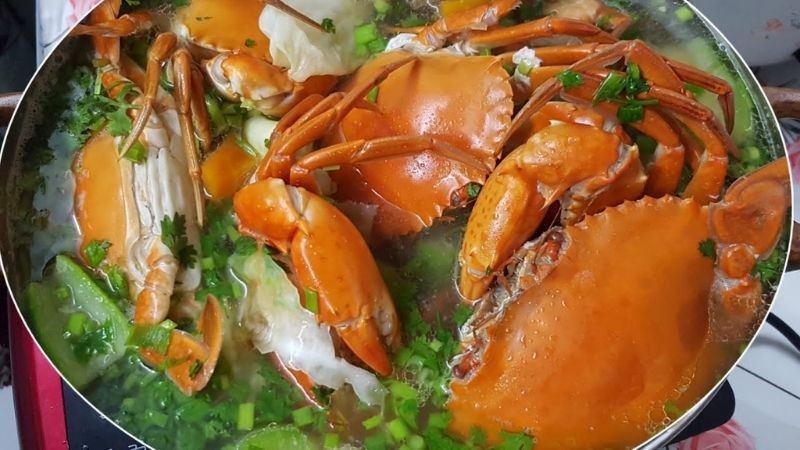 Nồi lẩu riêu cua biển nghi ngút khói, với các loại rau ăn kèm