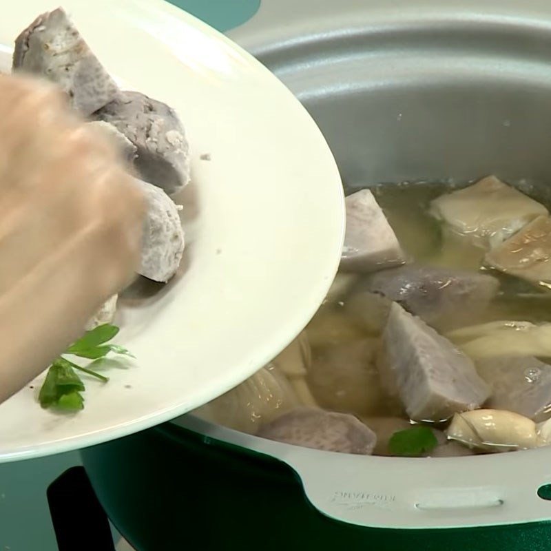 Khoai môn được thêm vào nồi nước dùng nấm bào ngư đang sôi, chuẩn bị cho giai đoạn cuối cùng của món canh khoai môn chay