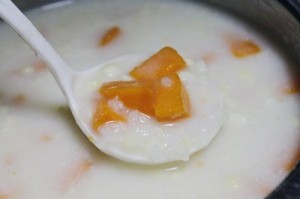 Gạo nếp và cùi bắp đang được đun sôi trong nồi, tạo nền tảng hương vị ngọt thanh cho chè ngô khoai lang