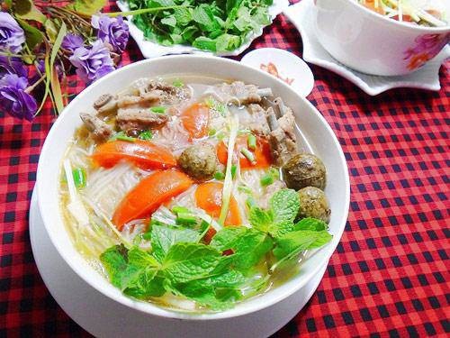 Chan nước dùng nóng hổi vào bát bún sườn dọc mùng đã chuẩn bị sẵn