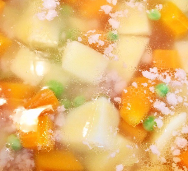 Canh khoai tây thịt băm đang được hầm trên bếp với các loại rau củ.