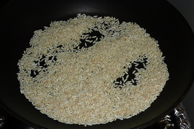 Rang gạo cho đến khi gạo hơi vàng để nấu cháo thịt bò bằm đơn giản cho bé ăn dặm.