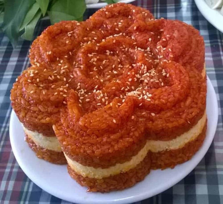 Đĩa xôi gấc đậu xanh thành phẩm với màu đỏ cam bắt mắt và lớp đậu xanh vàng mịn.