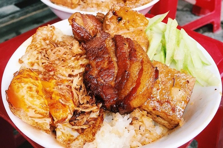 Cơm nếp nóng hổi ăn kèm đa dạng topping như chả, trứng, lạp xưởng và dưa góp