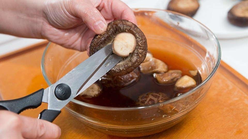 Nấm hương khô đang được ngâm nước để nở mềm, chuẩn bị cho công đoạn hầm gà hạt sen táo đỏ.