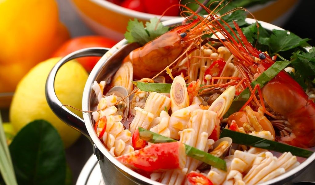 Bàn tiệc lẩu chua ngọt đầy đủ nguyên liệu, sẵn sàng để thưởng thức