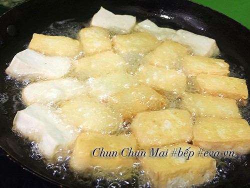 Đậu hũ được cắt miếng vừa ăn và chiên vàng giòn trong chảo dầu
