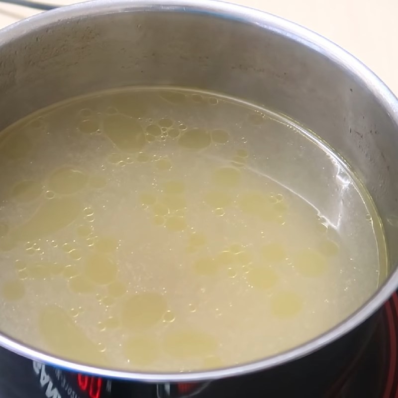 Thêm cà chua đã xào nhừ vào nồi nước dùng, bắt đầu nấu lẩu riêu cá chép