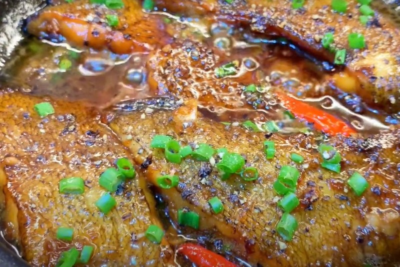 Hoàn thiện nồi cá kho tiêu với tiêu xanh và gia vị cuối cùng