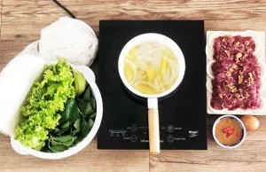 Nồi cá mè kho chuối xanh đang sôi nhẹ trên bếp lửa