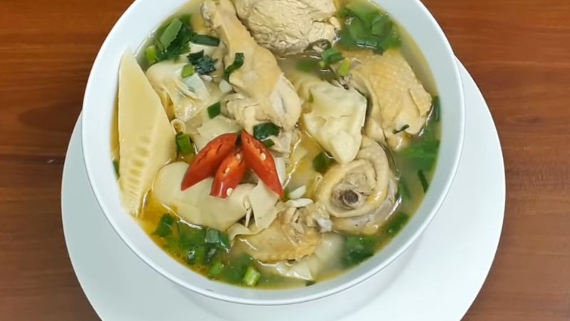 Hình ảnh bát canh măng thịt gà vàng óng, hấp dẫn với những miếng thịt gà và sợi măng mềm, điểm xuyết hành lá