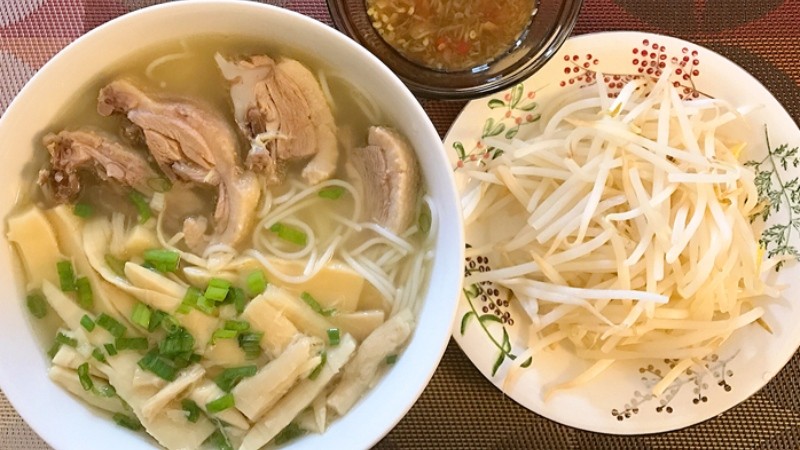 Hình ảnh bát canh măng thịt gà đã hoàn thành, màu sắc tươi sáng, với thịt gà mềm và măng giòn, rắc hành lá xanh