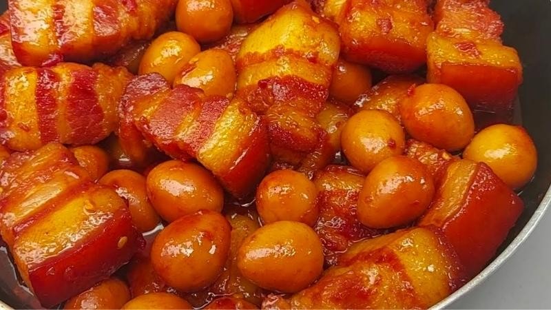 Thành phẩm món thịt kho nước dừa trứng cút được bày ra đĩa, trang trí thêm hành lá và ớt, hấp dẫn và thơm ngon