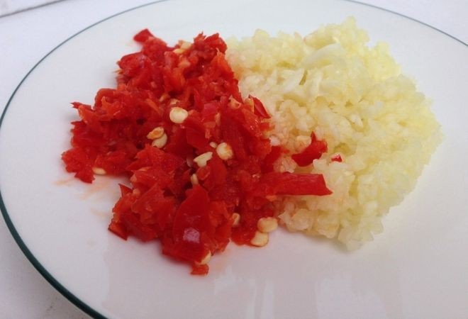 Băm nhỏ tỏi ớt để pha nước chấm cho món bầu luộc, ăn kèm tép tươi ngon