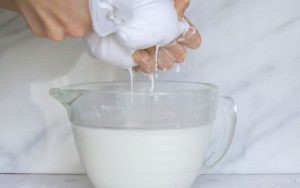 Vắt nước cốt dừa từ dừa nạo để tạo vị béo đặc trưng cho bánh canh