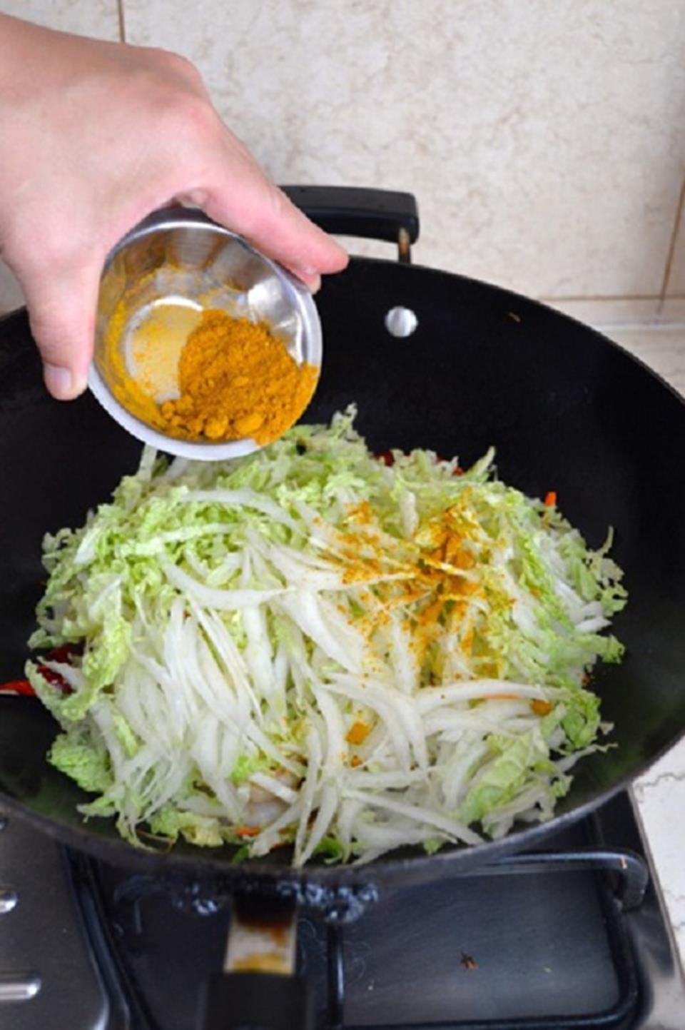 Các loại rau củ và nấm đã xào đang được nêm bột cà ri