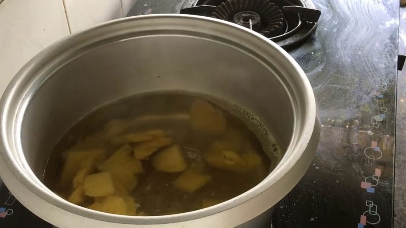Nồi nước canh đang sôi nhẹ với khóm xào thơm và nước cốt me