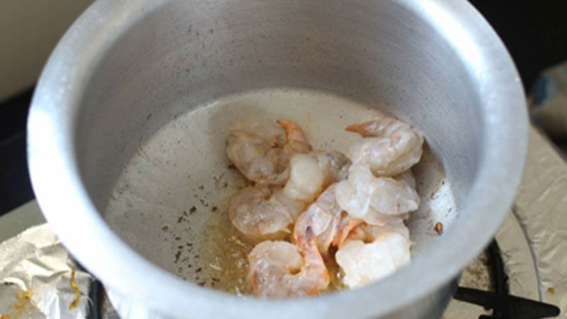 Xào tôm tươi trong nồi cho đến khi săn lại, bước đầu tiên trong cách nấu canh chua thơm