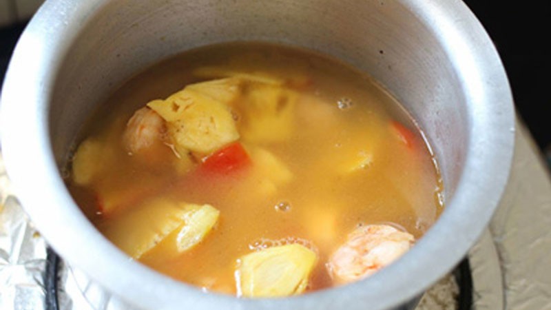 Thêm nước và nêm nếm gia vị cho nồi canh chua thơm, đảm bảo hương vị hài hòa