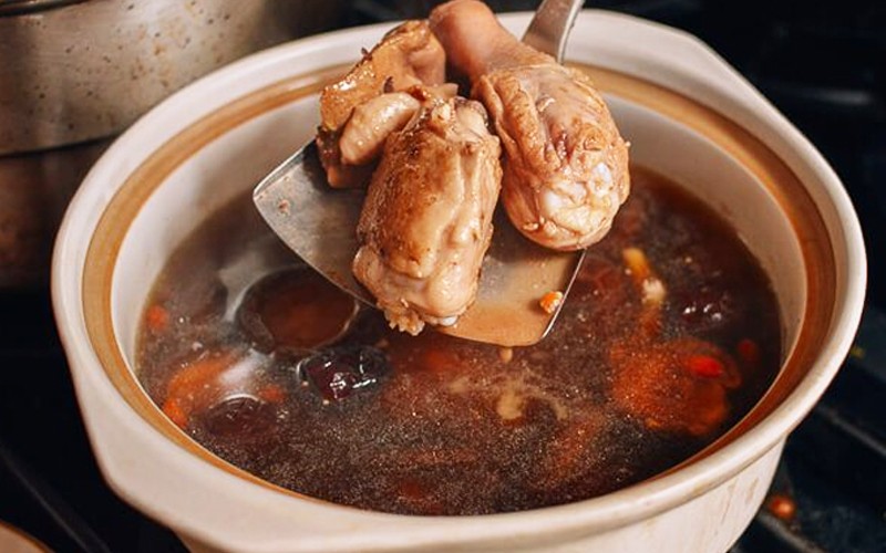 Nồi canh gà nấu nấm hương đang sôi trên bếp