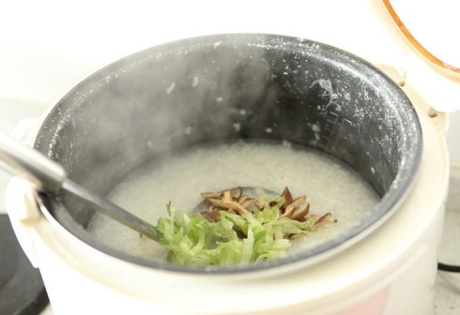 Nồi cháo đang được nấu trên bếp, có thể dùng nồi cơm điện để tiết kiệm thời gian.