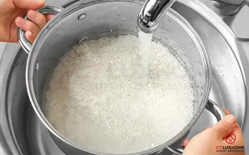 Đổ nước và thêm chút muối vào nồi gạo để chuẩn bị cho quá trình nấu cháo trắng bằng bếp ga