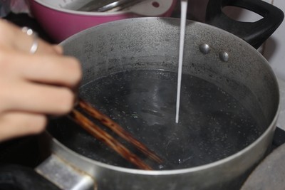 Cho mè đen vào nồi nấu chè và từ từ thêm bột sắn dây khuấy đều