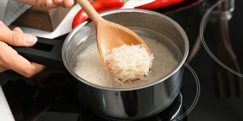 Cho gạo và nước vào nồi với tỷ lệ chuẩn để nấu cơm bằng bếp ga