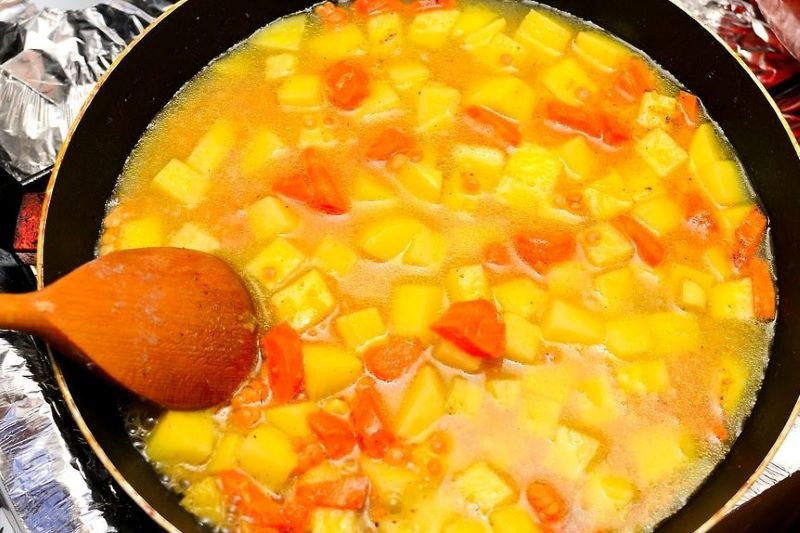 Kết hợp đậu lăng, gia vị và cà chua trong nồi súp