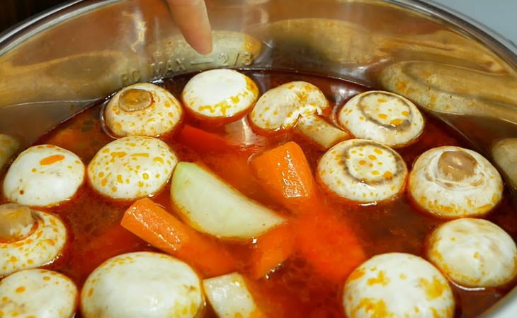 Sườn đang nấu trong nồi áp suất cùng rau củ, tạo nên nước dùng thơm ngon