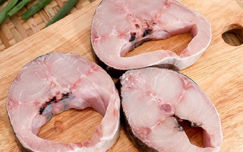 Cá bớp được cắt thành khoanh và tẩm ướp gia vị chuẩn bị nấu lẩu cá bóp măng chua