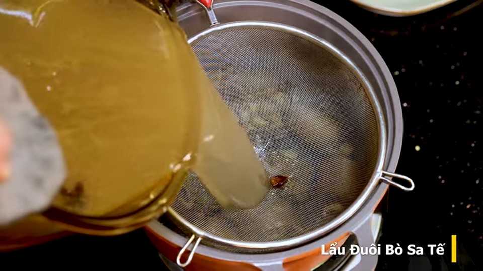 Nước dùng lẩu trong vắt sau khi lọc, chuẩn bị kết hợp với sốt sa tế và các nguyên liệu khác để tạo nên hương vị đặc trưng của lẩu đuôi bò sa tế.