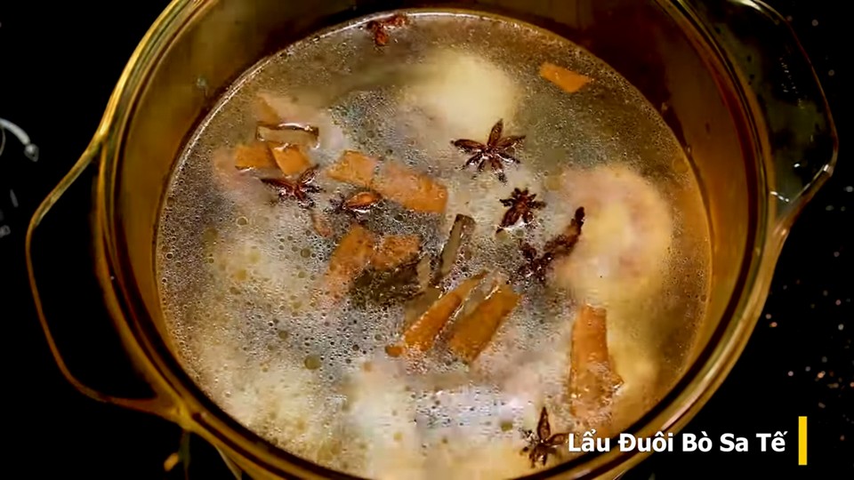 Đuôi bò đang được hầm nhừ trong nồi lớn, chuẩn bị cho món lẩu đuôi bò sa tế thơm ngon.