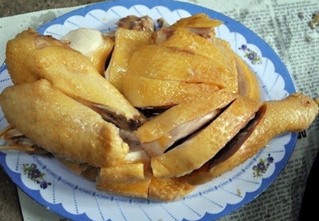 Con gà ta đang được luộc trong nồi nước dùng cho món miến gà