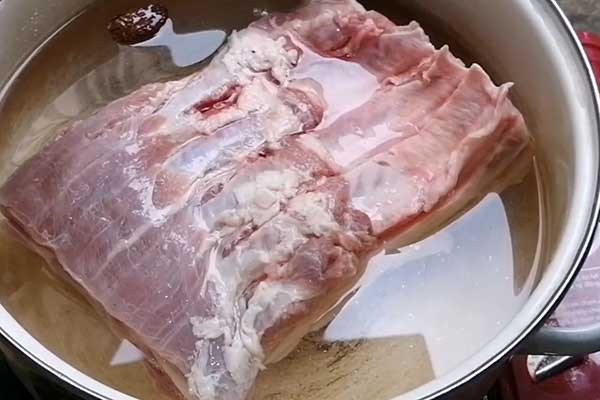 Thịt ba chỉ heo tươi ngon đang được luộc sơ để chuẩn bị cho cách nấu khâu nhục người Hoa