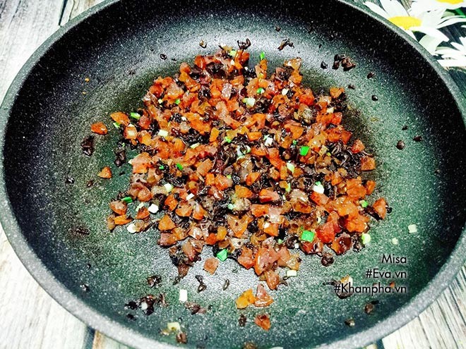 Lạp xưởng và nấm mèo đang được xào trên chảo cùng gia vị