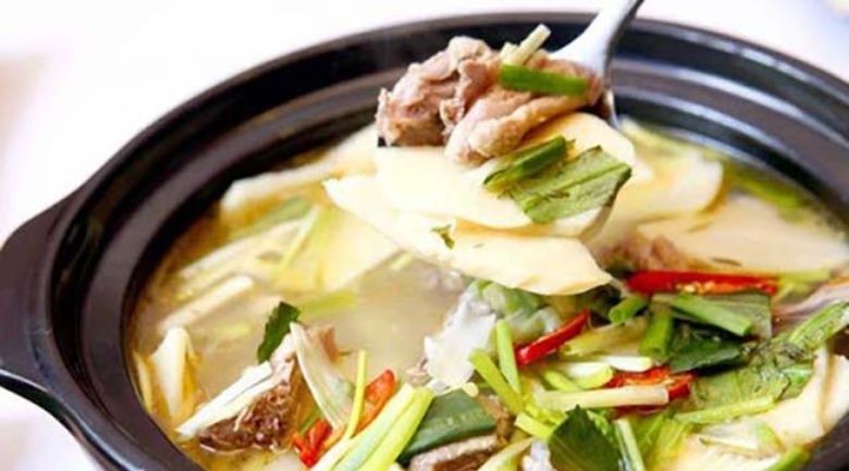 Xương chó đang được xào cùng măng tươi để tạo hương vị đậm đà