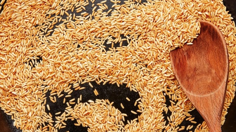 Gạo được rang vàng thơm trên chảo, bước chuẩn bị quan trọng cho món cháo hải sâm khô sò điệp