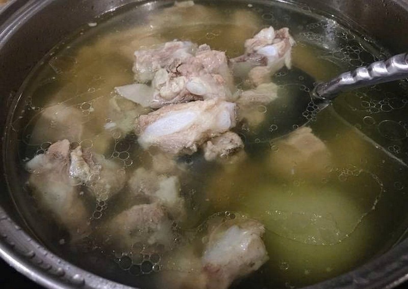 Nồi nước dùng lẩu gà ác đang hầm xương và gà, tạo độ ngọt thanh tự nhiên