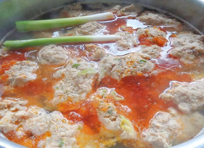 Nước lèo canh bún đang sôi với sắc cam đỏ đẹp mắt từ cà chua và gạch cua