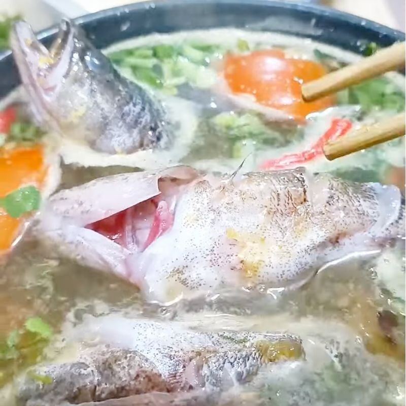 Thả nhẹ nhàng cá bống tượng vào nồi canh đang sôi để cá chín đều