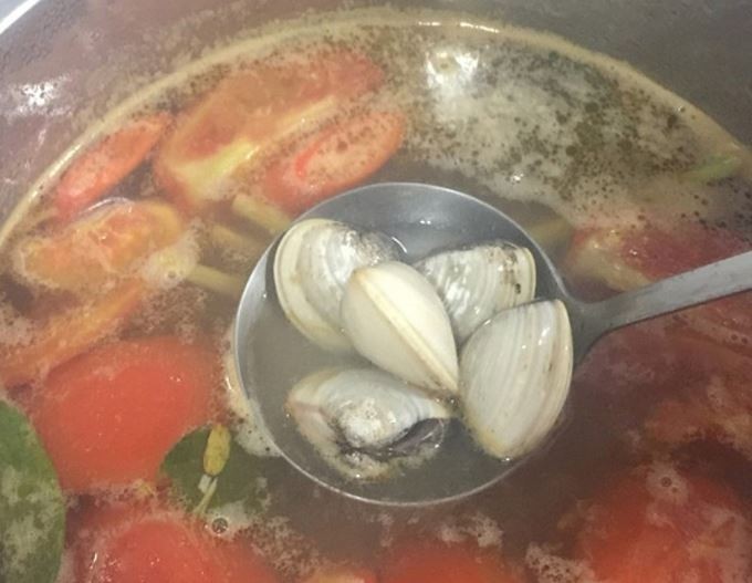 Nước cốt me chua được thêm vào nồi canh, tạo hương vị đặc trưng cho canh ngao me