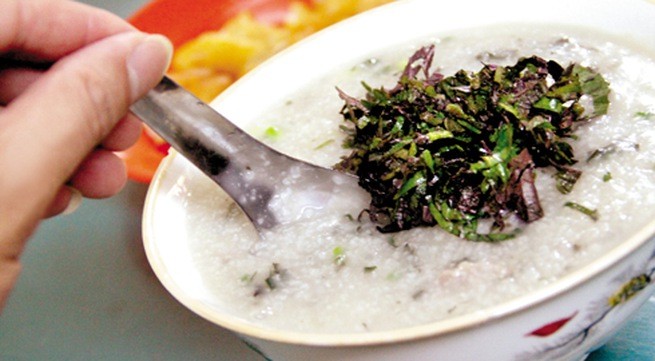 Bát cháo tía tô nóng hổi hoàn chỉnh, với trứng lòng đào và hành ngò, sẵn sàng bồi bổ cho người bị cảm.