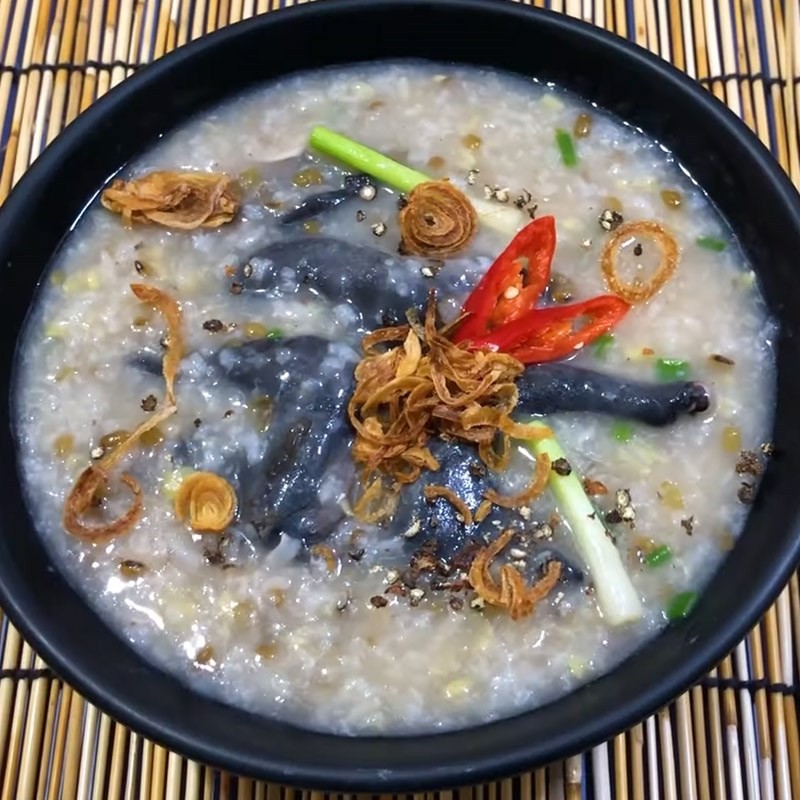 Cháo gà ác đậu xanh được trang trí với giá đỗ, hành lá và tiêu xay
