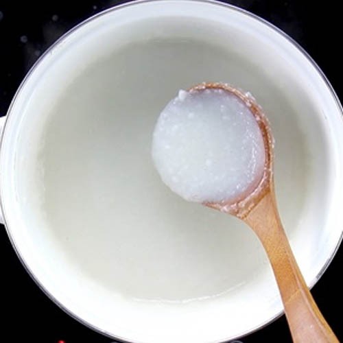 Dùng thìa khuấy đều liên tục khi nấu cháo bằng bột gạo tẻ để cháo sánh mịn
