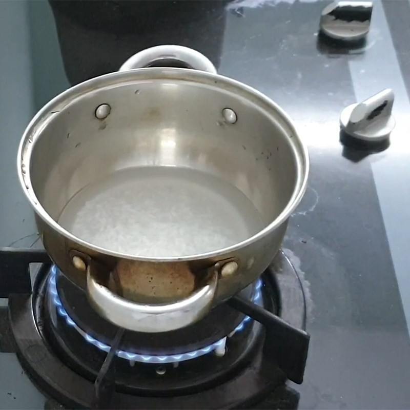 Nồi cháo trắng đang sôi nhẹ, gạo nở mềm, tạo nền tảng hoàn hảo cho món cháo ngọt tôm cải phô mai cho bé