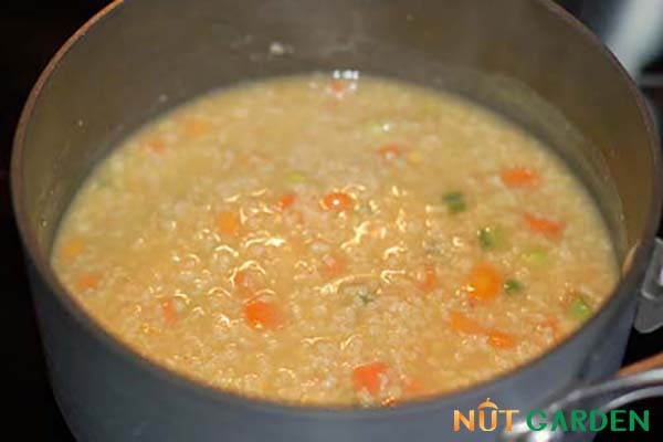 Bát cháo yến mạch nguyên hạt nóng hổi với thịt băm và ngô, sẵn sàng thưởng thức