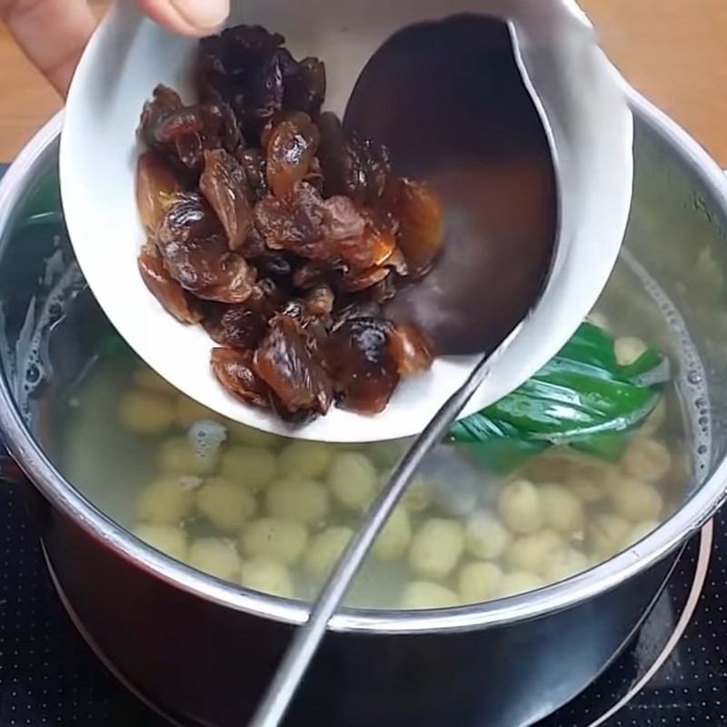Thêm đường vào nồi chè hạt sen đang nấu