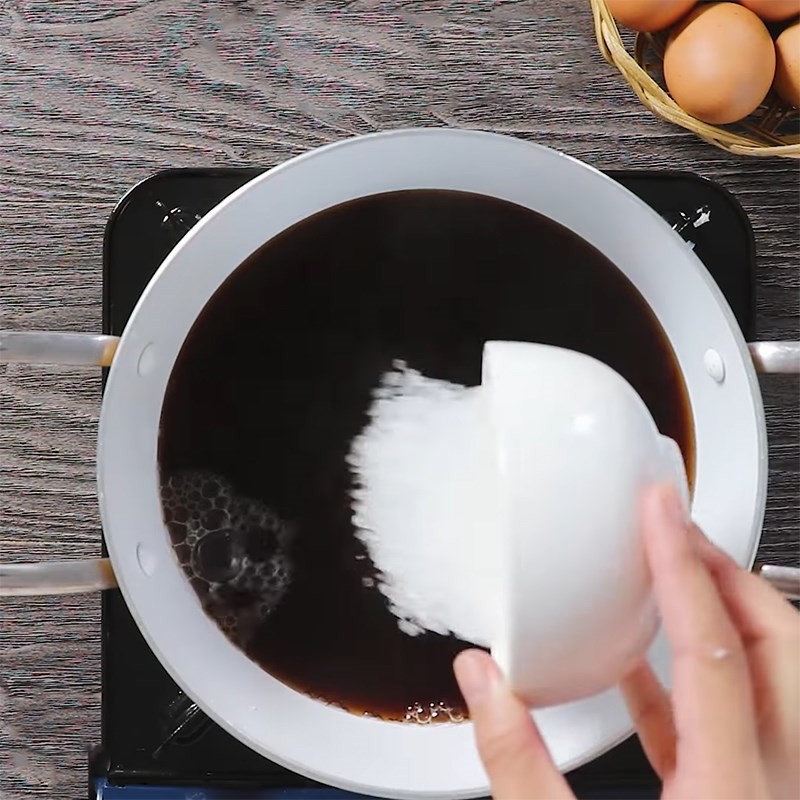 Trứng gà đang được đun nhỏ lửa trong nồi nước trà và đường phèn