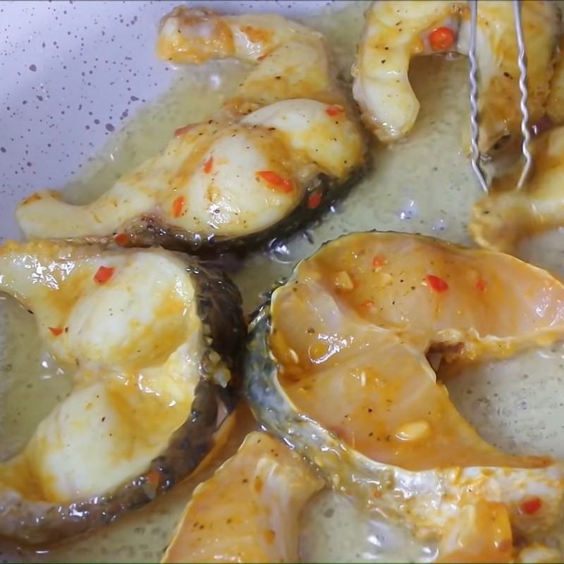 Những miếng cá lóc đang được chiên vàng đều trong chảo dầu nóng